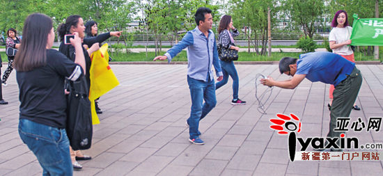 昨日下午，在乌市迎宾路一家酒店门口，王先生就自己打狗的过激行为向爱狗人士鞠躬道歉。亚心网记者 史纪伸 实习生 田园 摄