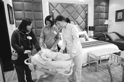护理人员在给前来咨询的孕妇介绍婴儿车的使用。中新社发 渝友 摄