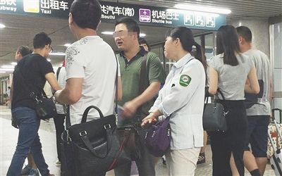 7月4日，北京西站A1出口，一名女医托身着带有“北京公交集团”字样的衣服，与两名同伙聊天。