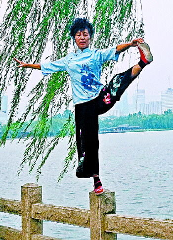 大妈在大明湖畔的栏杆上做出各种高难度动作
