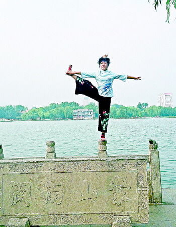 大妈在大明湖畔的栏杆上做出各种高难度动作