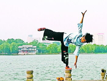 大妈在大明湖畔的栏杆上做出各种高难度动作