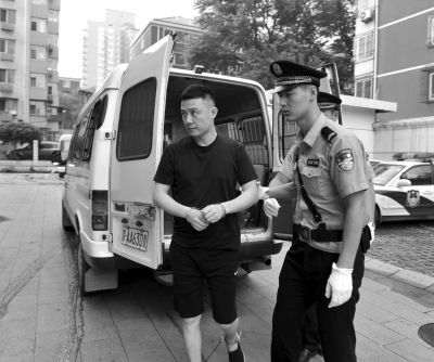 身穿便装的张林被法警带下警车。京华时报通讯员 曹璐 摄