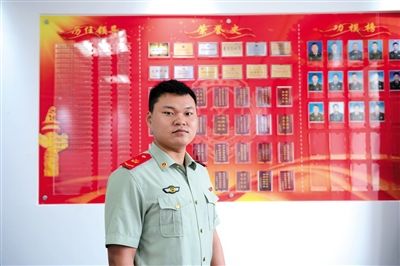 近日，杜宝珠在部队的荣誉墙前，上面有张丽晓的名字。 新京报记者 吴江 摄