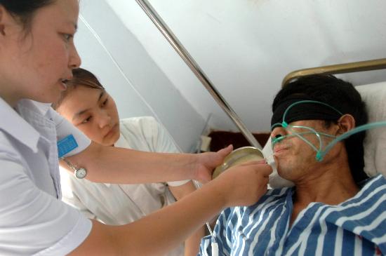 图文:两名护士帮助获救矿工用吸管吸食小米粥