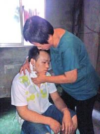 李绍连查看儿子透析的针头。