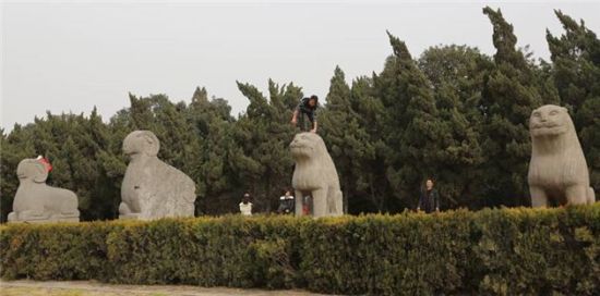 游客踩文物石像拍照