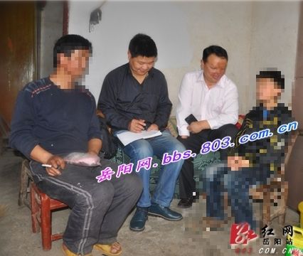 岳阳市残联工作人员向熊川父子了解情况。