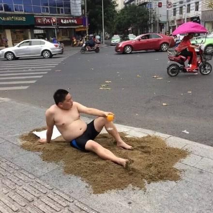 ▲早前，躺在成都市中心路口的行为艺术家何利平 图 |微博截图