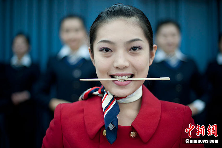 组图:动车"乘姐"集训迎春运 美女咬筷子练笑容
