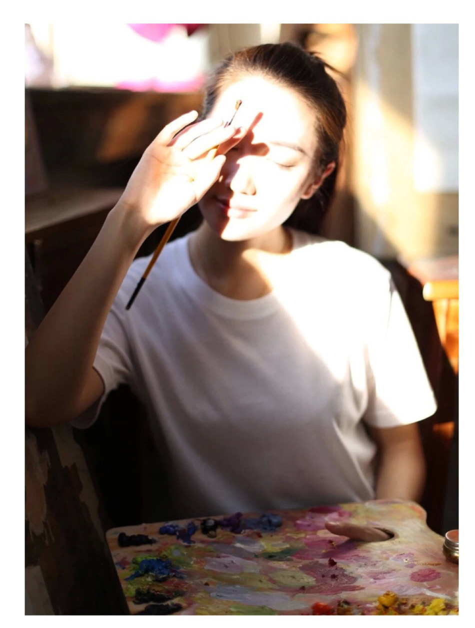 照片中她扎起马尾,执笔作画,神情认真专注,画面唯美动人.