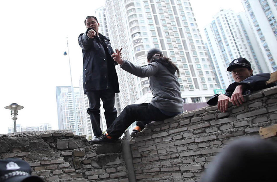 翻墙取水遭围堵 深圳拆迁户骑墙头与保安对话