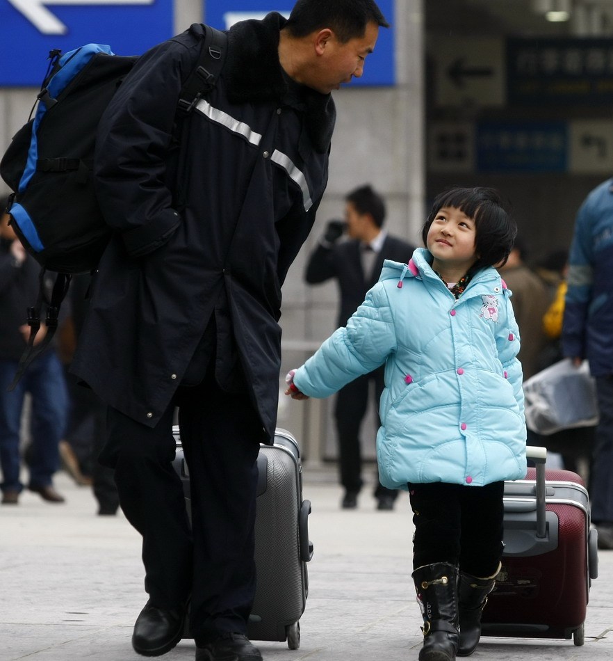 父亲牵着孩子的手准备登车