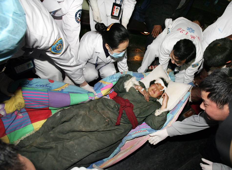 伤员抵达成都双流机场后被护送下飞机