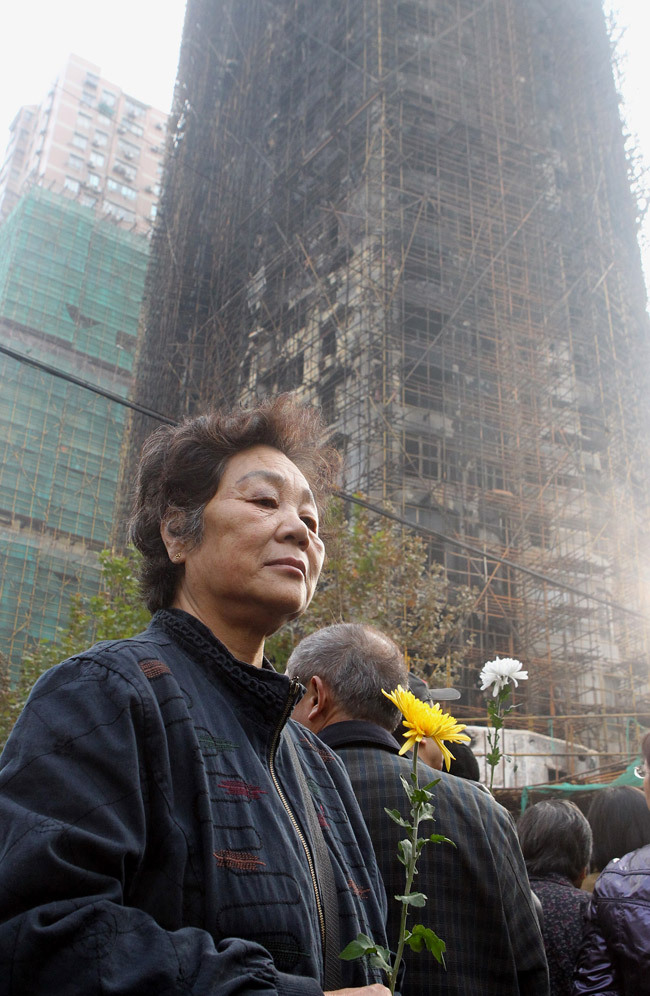 遇难者亲属以及社会各界人士纷纷来到胶州路728号火灾事故现场,向事故
