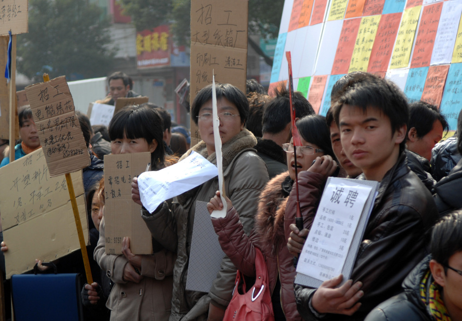 2月12日,浙江义乌劳动力市场,众多举牌招聘的用工企业代表在等待应聘