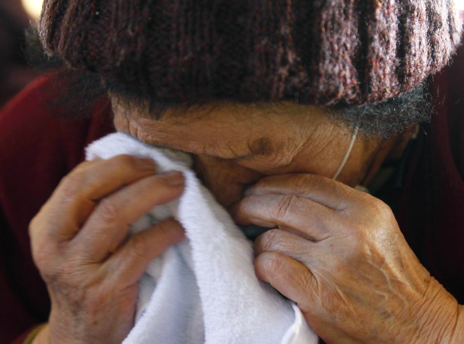 一名从地震灾区被疏散的老人在哭泣