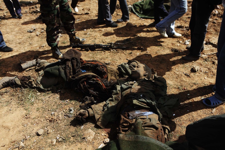 当地时间3月20日,班加西,政府军的坦克和飞机停在路边,周围散落着十几