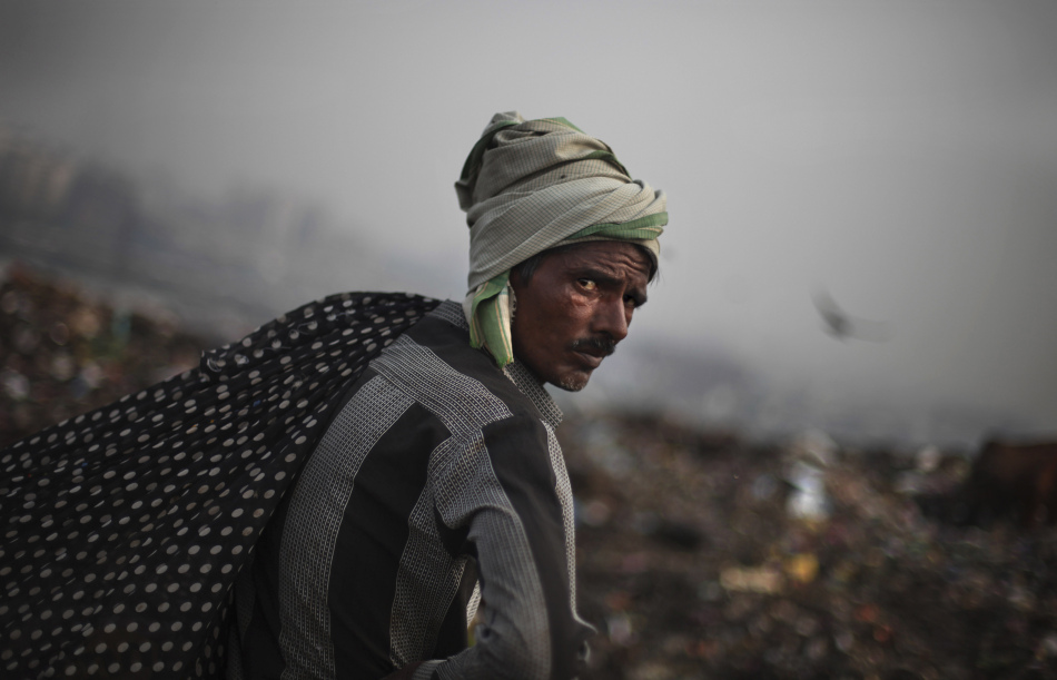 当地时间2012年9月13日,印度新德里郊区,一名拾荒者前往垃圾场中捡