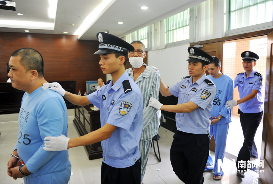 原石碣执法分局局长梁某忠等4人被法警押进法庭受审