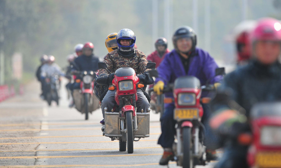 骑车返乡人员在春运服务站休息后继续行进