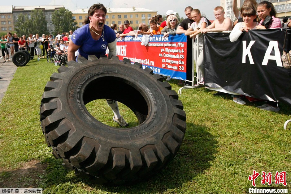 俄罗斯女大力士比赛滚轮胎拉汽车