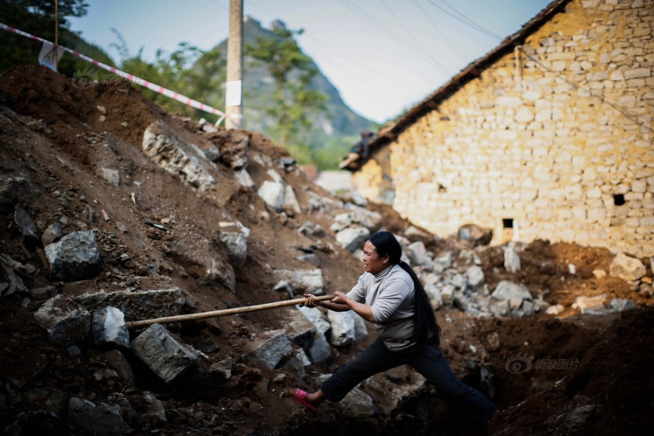 吴金敏在修葺自家房子的时候下地挖土.摄影:pen一杨/东方早报