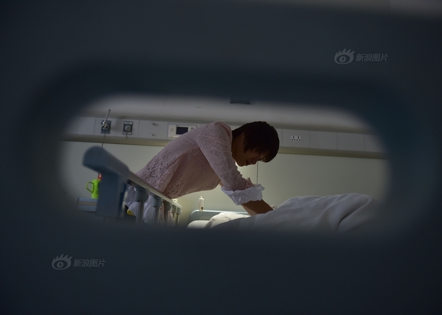 熊燕子照顾躺在病床上的女儿高慧.
