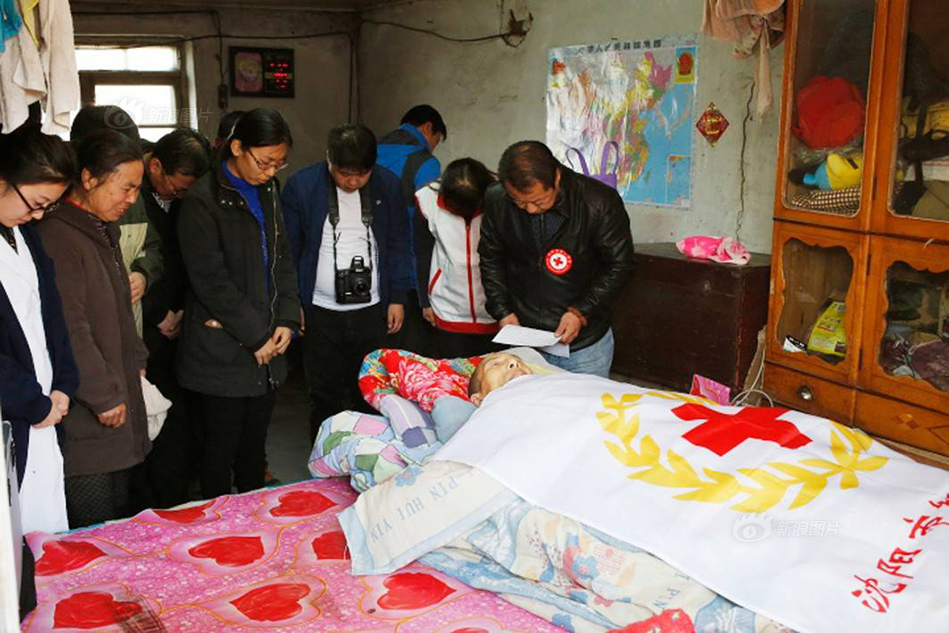 红十字会的志愿者和逝者的亲友一起向遗体鞠躬,进行遗体告别仪式.