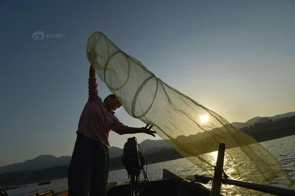 张春建的妻子苏茂在放虾笼前仔细检查有无破损.
