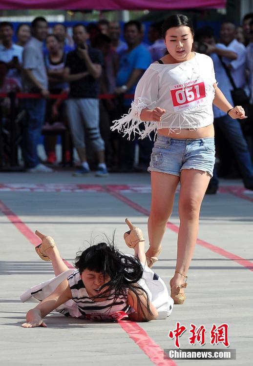 图为一名女子脚穿高跟鞋赛跑不幸摔倒. 韦亮 摄