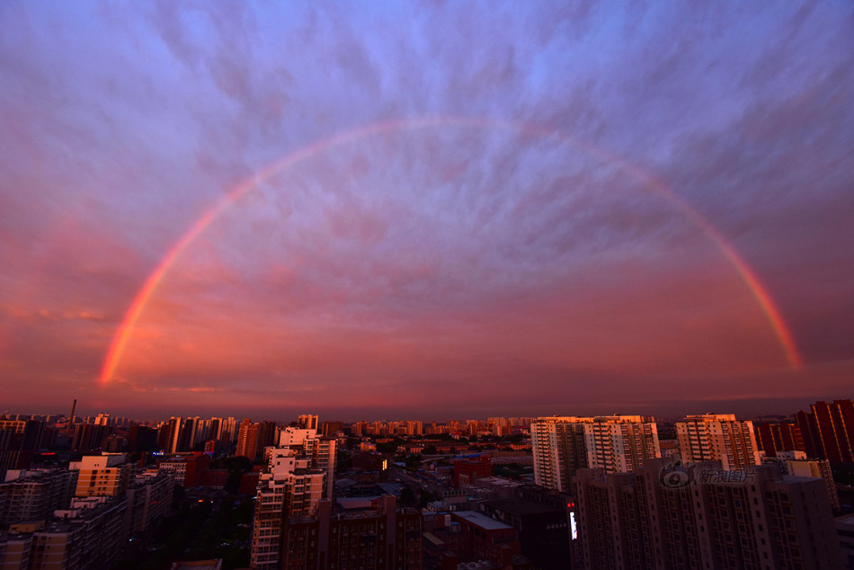 一条大彩虹高挂天空,非常壮观,同时天边还有大量的层积云,在阳光映衬
