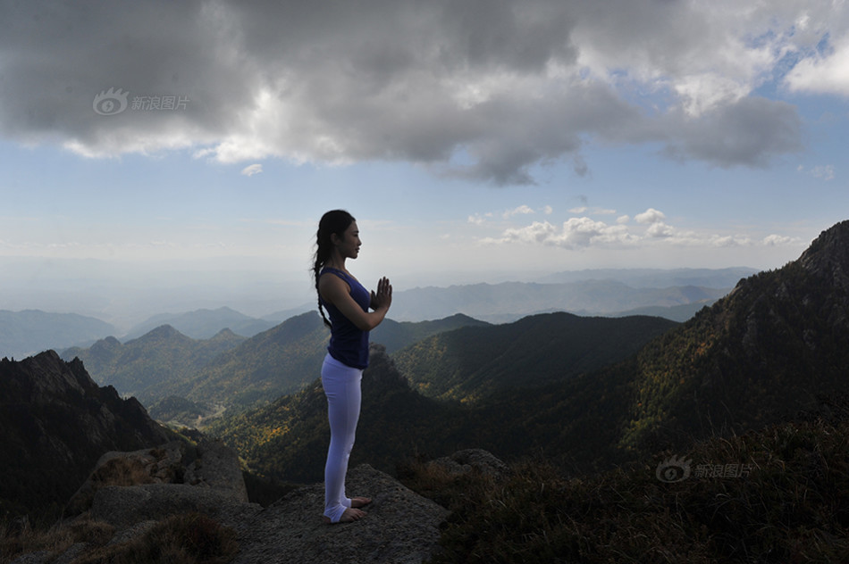 在这秋高气爽的境界中,瑜伽教练李雨桐,开始了她的表演,青松之下,悬崖