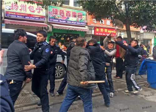 楚天都市报记者迅速赶到现场,4名男子正手持约一米长的木棍击打城管