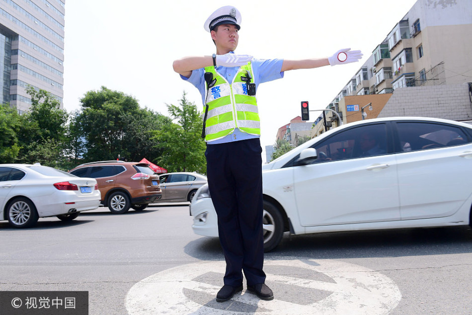 沈阳85后帅交警烈日坚守岗位接受"烤"验