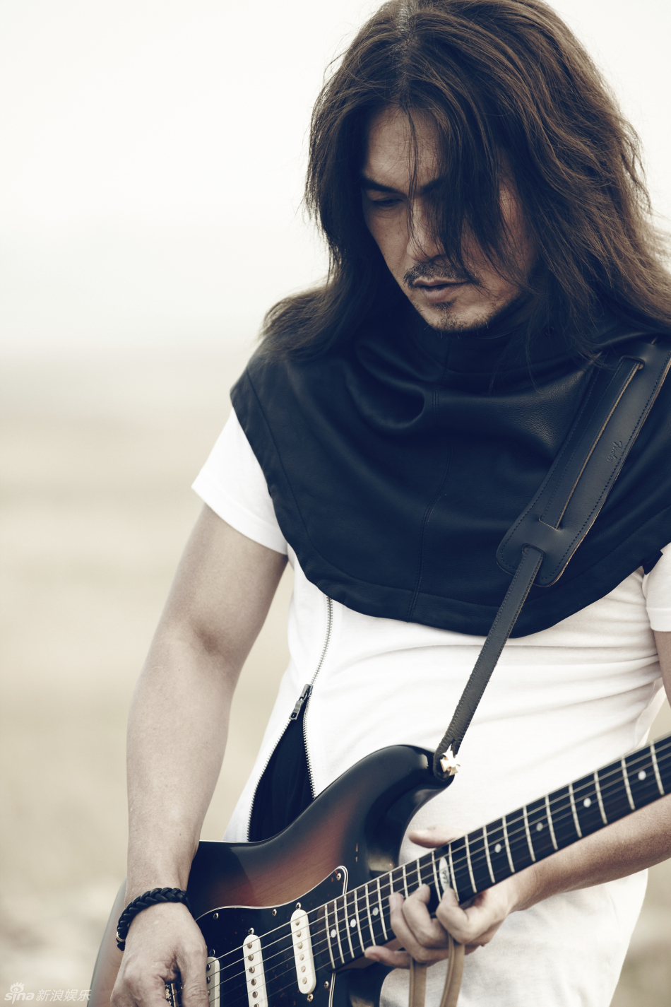 图为其颓废写真,迪克牛仔长发飘逸专注音乐.