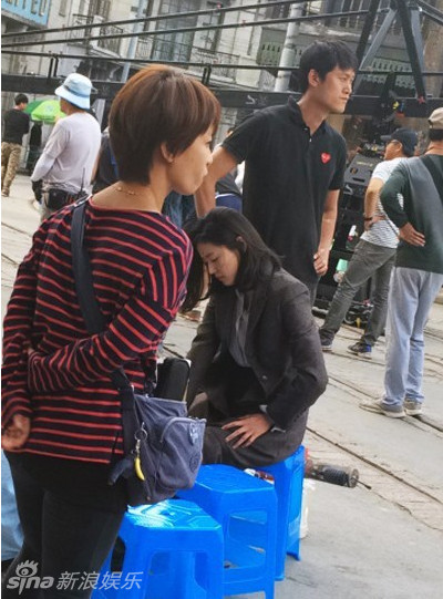 【2014.10.13】【影视】全智贤剪短发拍戏 片场助理帮穿鞋