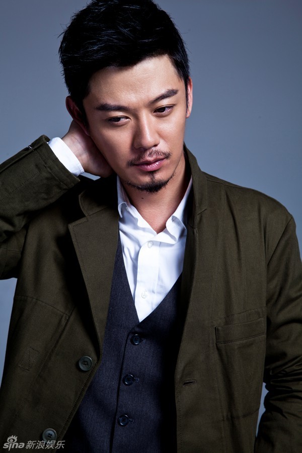 写真中,芦芳生大胆挑战蓝色格纹西装,手拿复古礼帽,眼神时而冷峻,时而