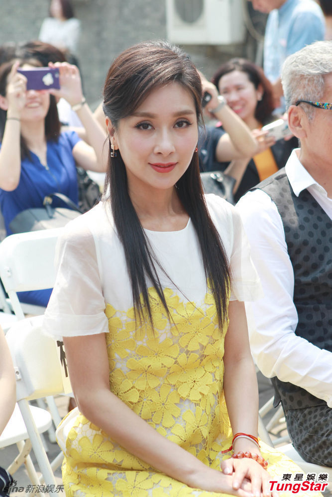 杨恭如顶烈日为公益站台 黄裙清新大方