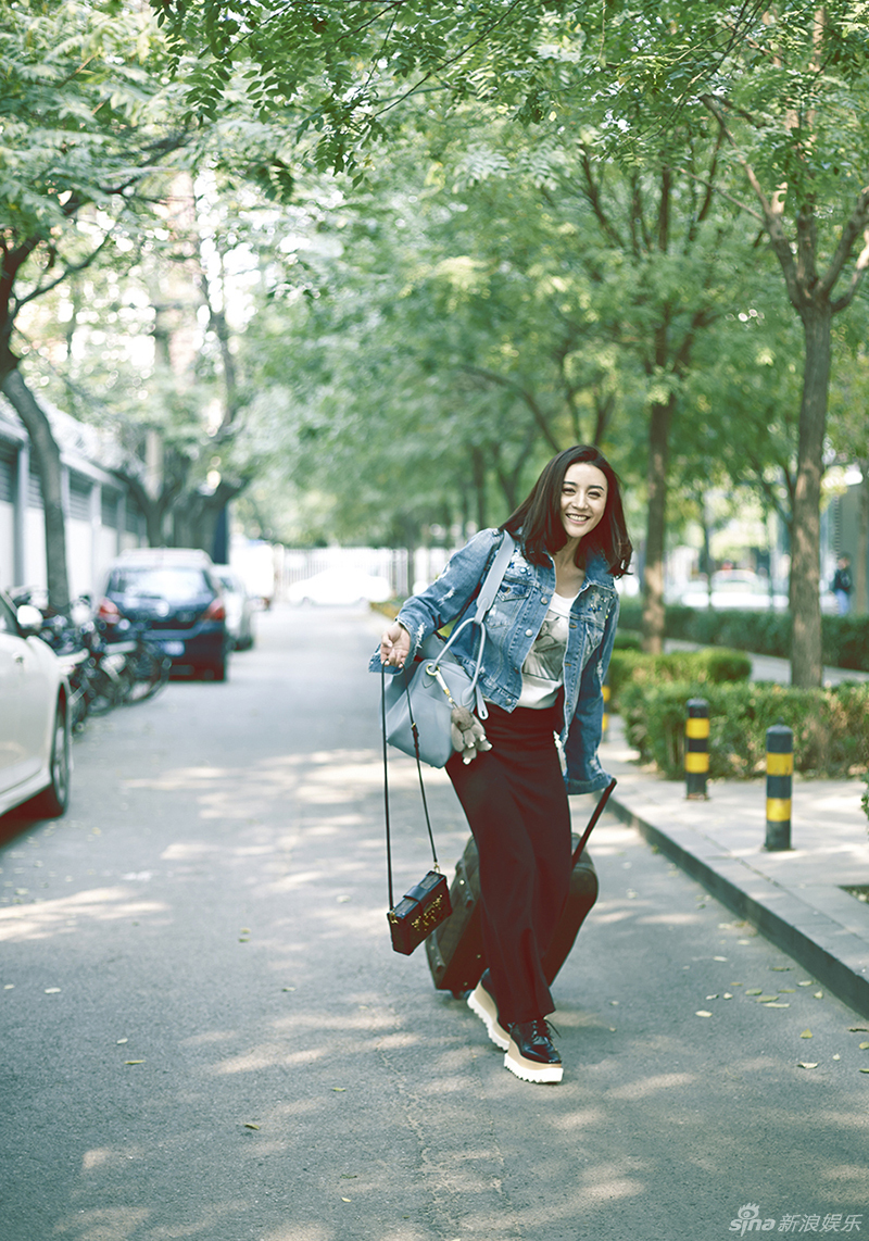 照片中的周庭伊身着牛仔短外套和黑色长裙,徜徉在秋日的阳光下,显得