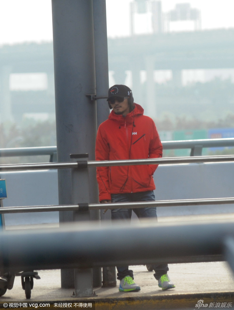 谢霆锋橙色外套现身机场 抽雪茄架势十足