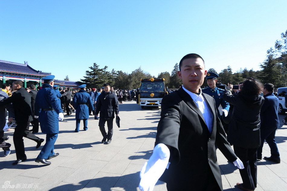 阎肃先生儿子阎宇抱遗照表情肃穆.(摄影/夏祺)