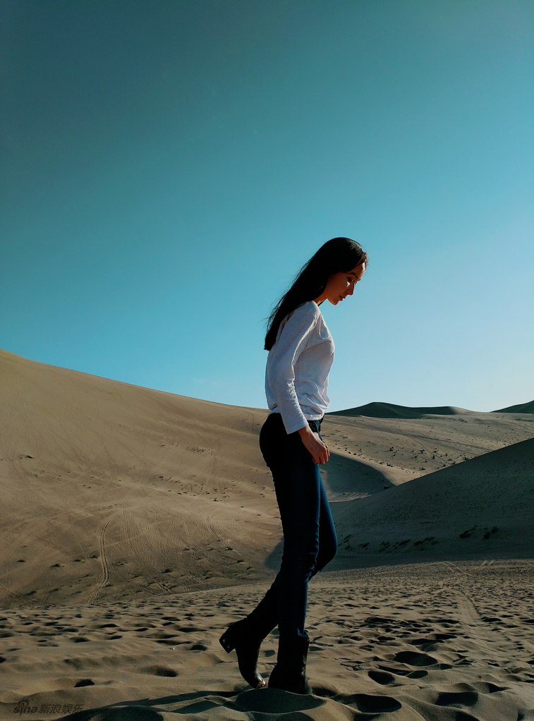 娄艺潇穿着简约,置身于蓝天沙漠间,显得相当飒爽有型.
