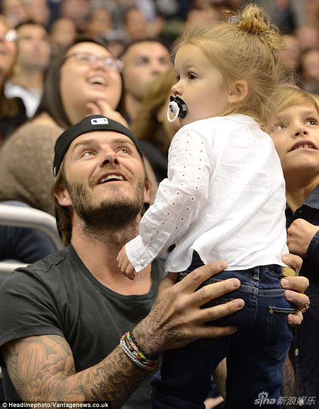 既任由其抠鼻,挠头,抢帽子和摸脸以后,小贝竟然将女儿的小拳头含到