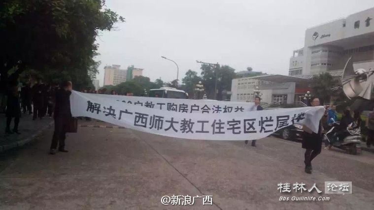 大学雁山校区的老师集体拉横幅,要求解决学校教工住宅区烂尾楼问题