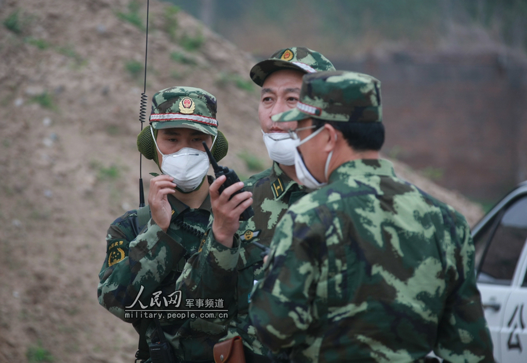 一名武警少校指挥员中正在用对讲机下达指令