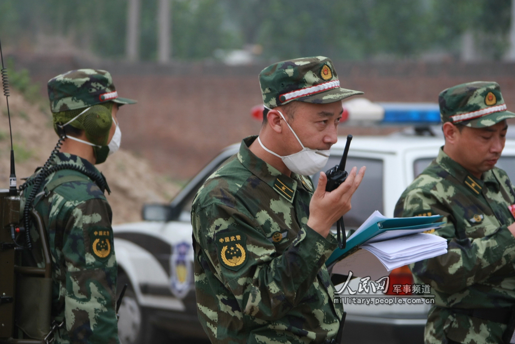 警少校指挥员正在用对讲机下达指令