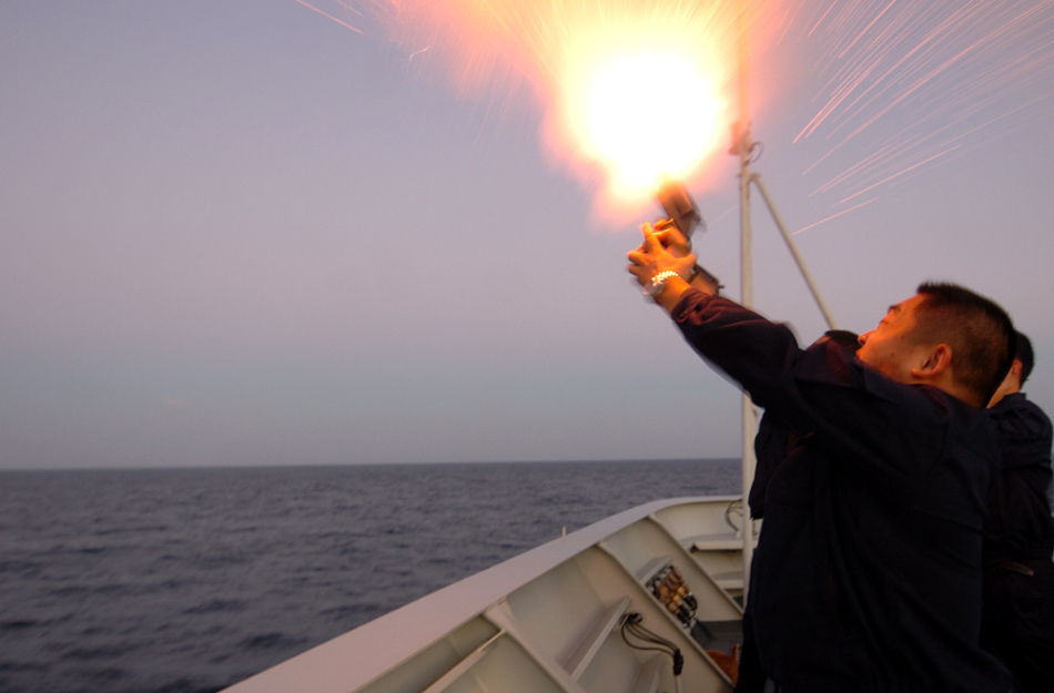 分航仪式上舟山舰的信号兵正在前甲板向空中发射彩色信号弹