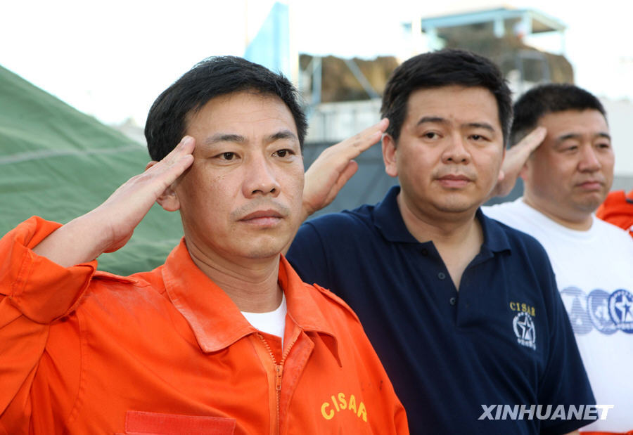 中国国际救援队搜救队队长刘向阳(左)向中国遇难者遗体敬礼