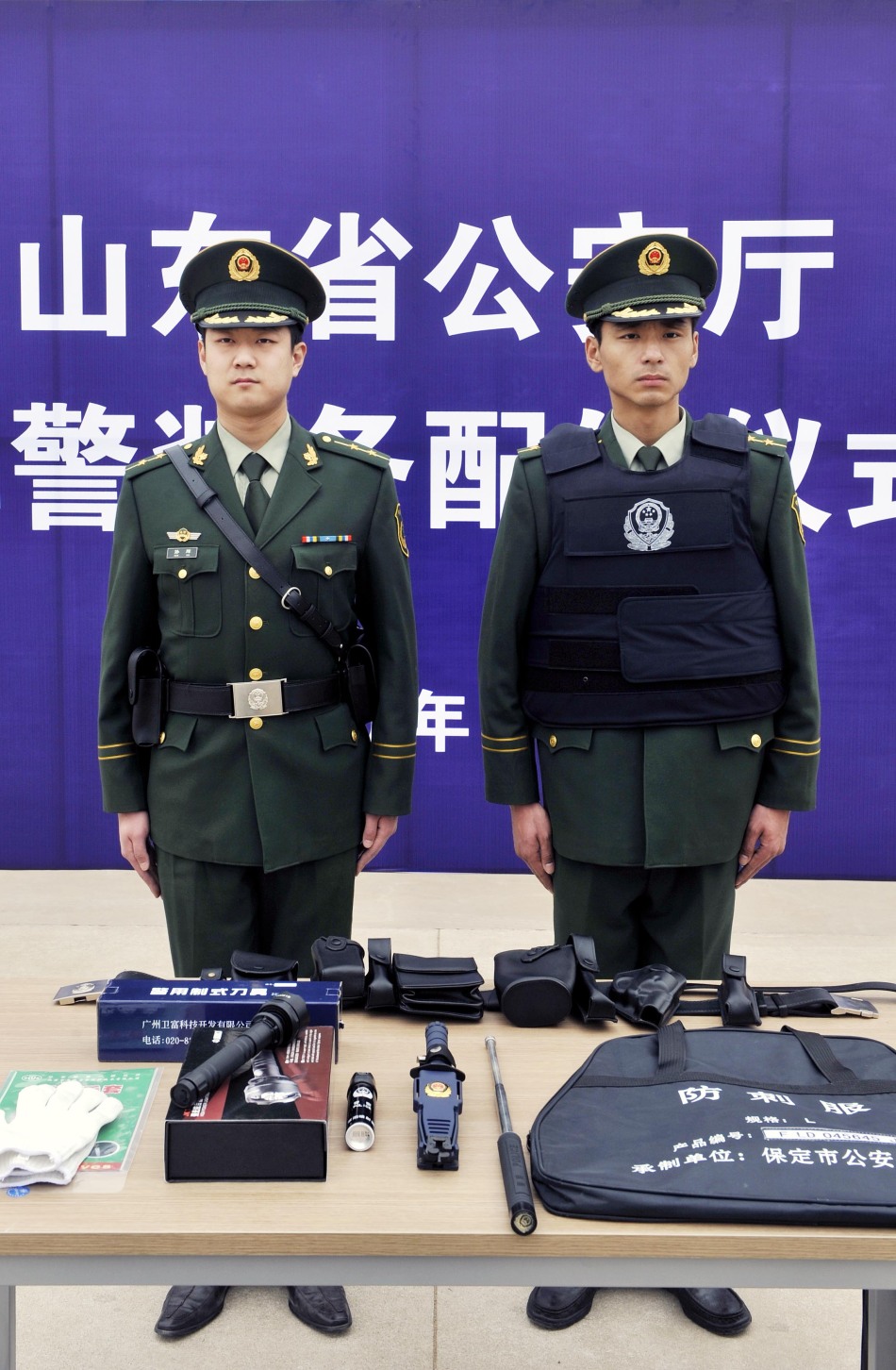 两名边防干警在展示配发的新型单警装备